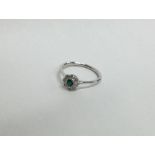 A pretty emerald and diamond cluster ring in 18 ca