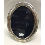 A large oval silver picture frame. London. By RC.
