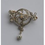 A large diamond brooch in the form of a scroll wit