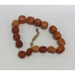 WITHDRAWN: A large string of amber beads of tapering form on gold chain. Ap