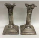 A pair of Corinthian column dwarf candlesticks on