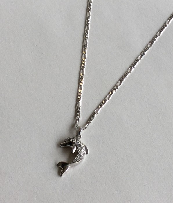 A diamond pendant in the form of a dolphin on fine