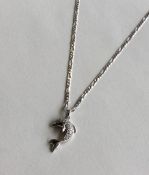 A diamond pendant in the form of a dolphin on fine