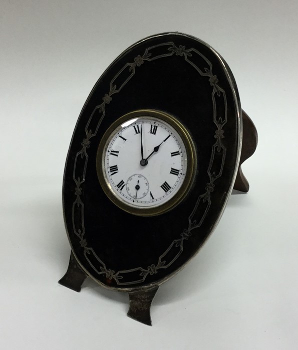 A stylish silver and tortoiseshell clock with whit
