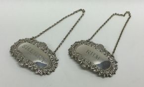 A pair of modern silver wine labels decorated with