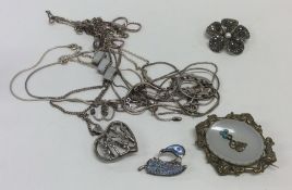 A bag containing silver pendants, brooches and ear