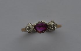 A ruby and diamond three stone ring in claw mount.