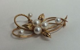 A pearl brooch in the form of a flower in 18 carat