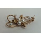 A pearl brooch in the form of a flower in 18 carat