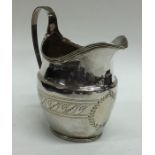 A Georgian silver bright cut cream jug with reeded
