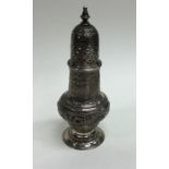 A Georgian silver embossed sugar caster profusely