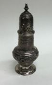 A Georgian silver embossed sugar caster profusely