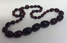 A graduated string of tapering red beads with conc