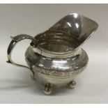 A Georgian style silver cream jug with bright cut