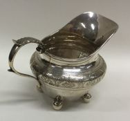 A Georgian style silver cream jug with bright cut