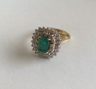 A large emerald and diamond double row cluster rin