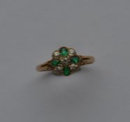 An attractive emerald and diamond cluster ring wit
