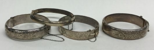 Four silver hinged bangles. Approx. 103 grams. Est