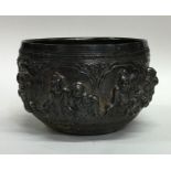 A heavy Indian silver bowl decorated with figures.