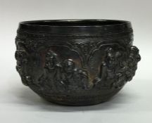 A heavy Indian silver bowl decorated with figures.