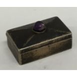 A modern silver hinged top silver pill box with ca