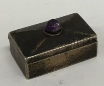 A modern silver hinged top silver pill box with ca