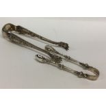 A pair of Victorian cast silver sugar tongs togeth