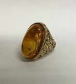 A heavy amber single stone ring with textured 9 ca