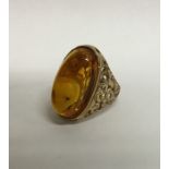 A heavy amber single stone ring with textured 9 ca