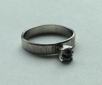 A modernistic sapphire single stone ring in 18 car