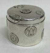 A cylindrical Japanese silver box decorated with f