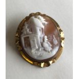 An oval cameo of a village scene in pinch-back fra