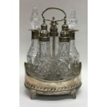 A heavy Georgian five bottle silver cruet on sprea