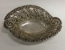 An embossed Edwardian silver bonbon dish decorated