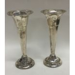 A pair of Edwardian silver spill vases on fluted b