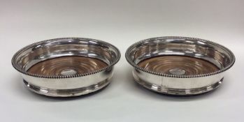 A pair of silver plated wine coasters. Est. £20 -