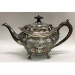 A good quality embossed silver teapot decorated wi