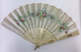 A carved Victorian fan with floral silk decoration