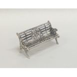 A silver model of a garden bench with slats. Appro