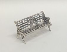 A silver model of a garden bench with slats. Appro