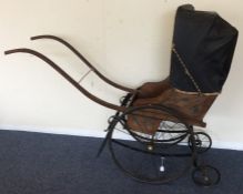 An old Victorian pram with spoked wheels and leath