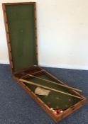 A mahogany cased ball game with fitted interior an