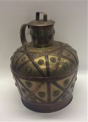 A massive brass flagon with copper strap work and