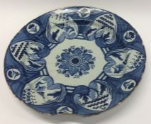 An Antique pottery charger decorated in blue and w