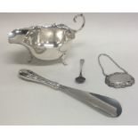 A silver sauce boat together with a silver wine la