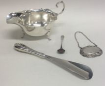 A silver sauce boat together with a silver wine la