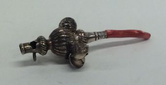 A Georgian silver rattle together with matching te