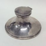 A large circular silver capstan shaped inkwell wit