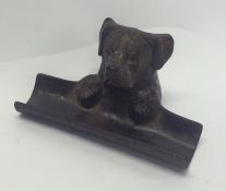 A cast pen tray in the form of a dog with textured