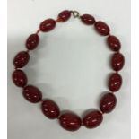 A graduated string of red amber beads. Approx. 80
